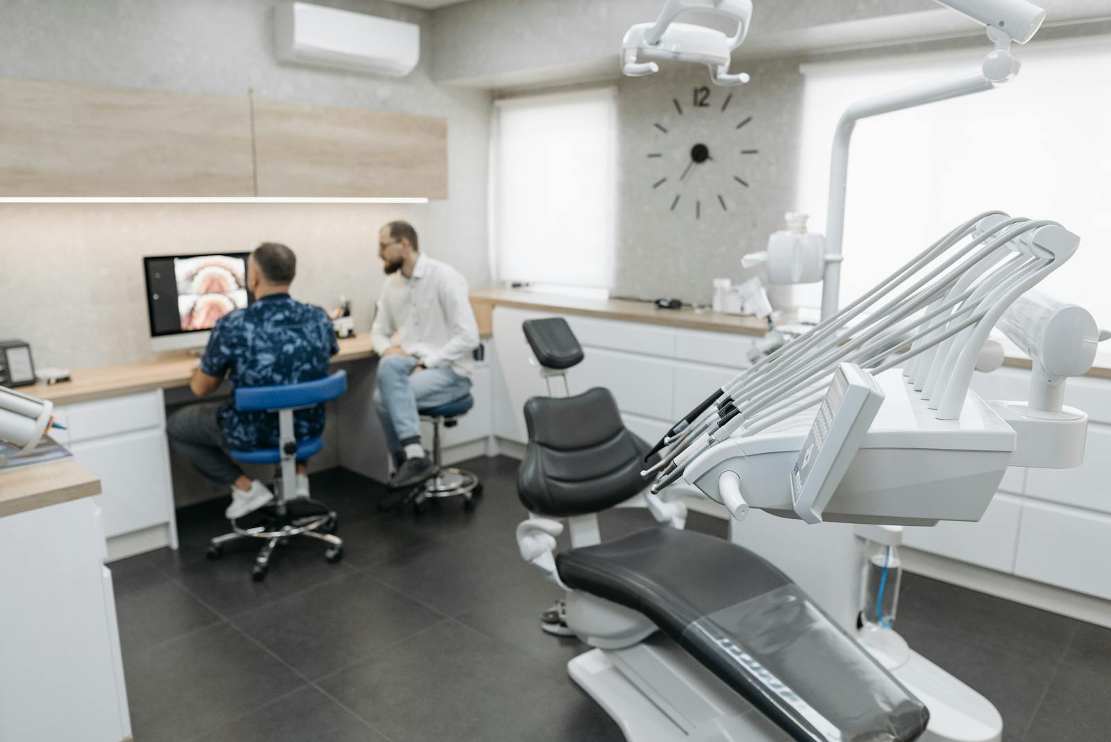 A dentist talking with a patient at Stillwater Dental, reviewing things together